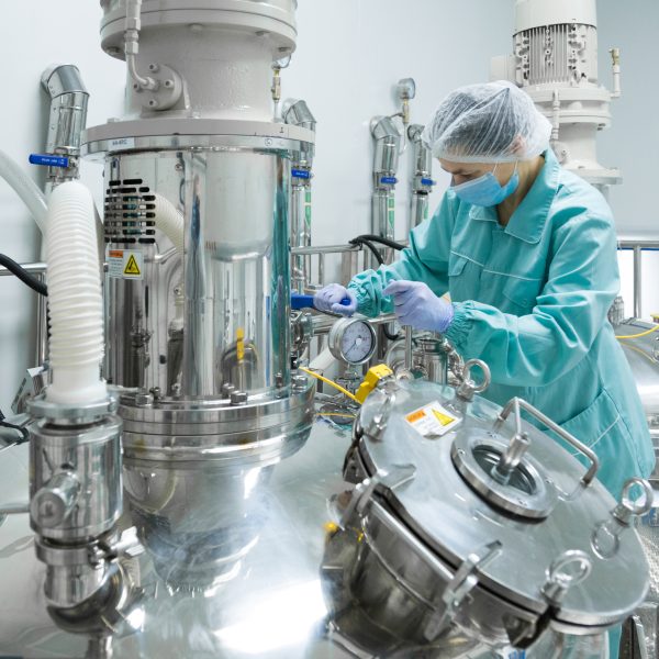 Pharmaceutical factory woman worker protective clothing operating production line sterile environment 600x600
